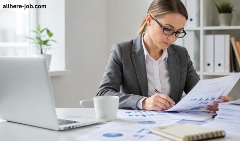 Businesswoman reviewing reports and charts at a desk in a modern office